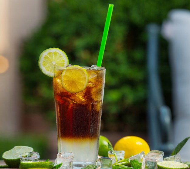 Un vaso de cóctel rojo mojito con rodaja de limón, lima sobre un fondo de restaurante - Imagen