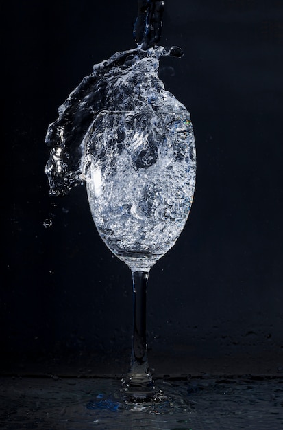 Vaso de cristal con agua en movimiento