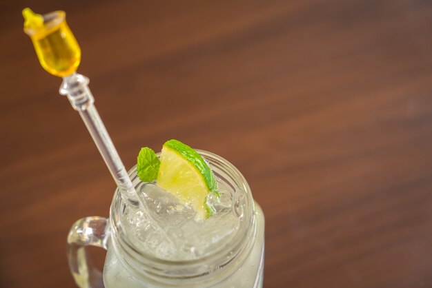 Vaso de cristal con bebida con hielo y limón