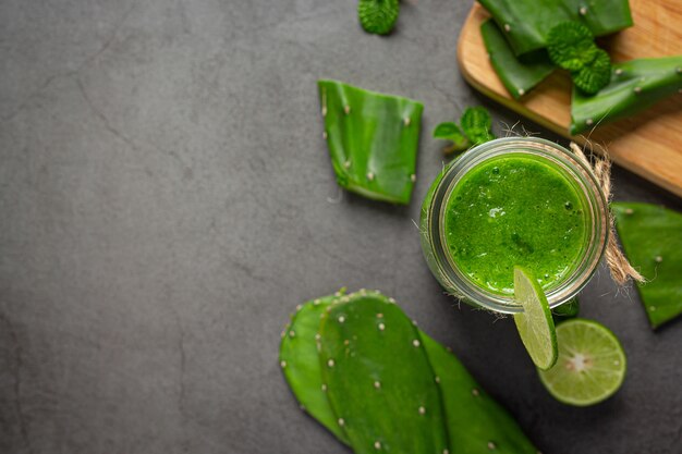 Vaso de jugo de aloe vera en piso oscuro