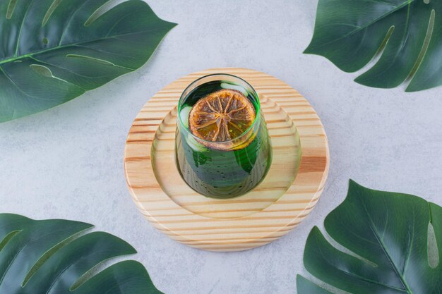 Vaso de jugo de estragón en placa de madera. Foto de alta calidad