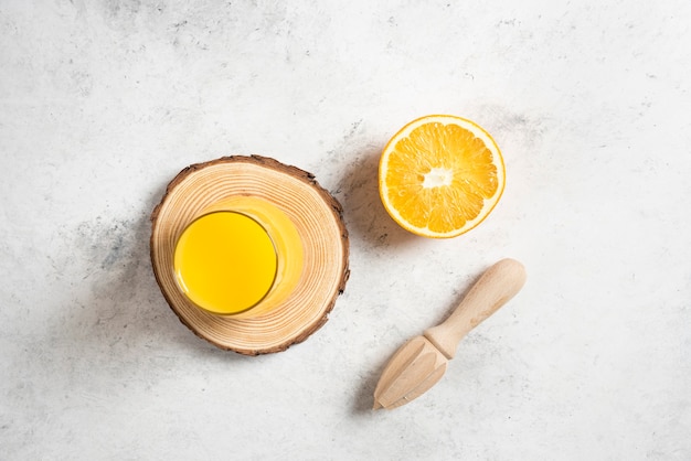 Un vaso de jugo fresco con una rodaja de naranja.