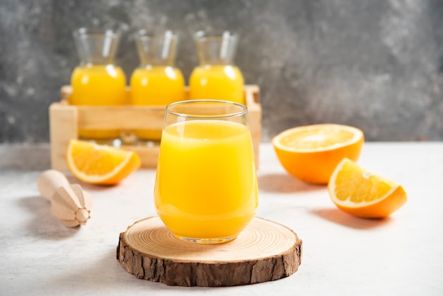 Un vaso de jugo fresco con rodajas de naranja.
