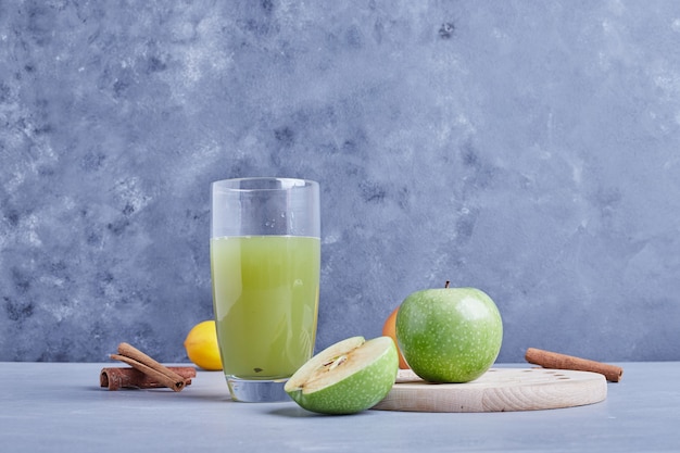 Foto gratuita un vaso de jugo de manzana verde.