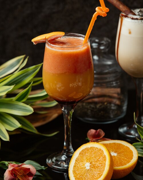 un vaso de jugo de naranja adornado con piel de naranja