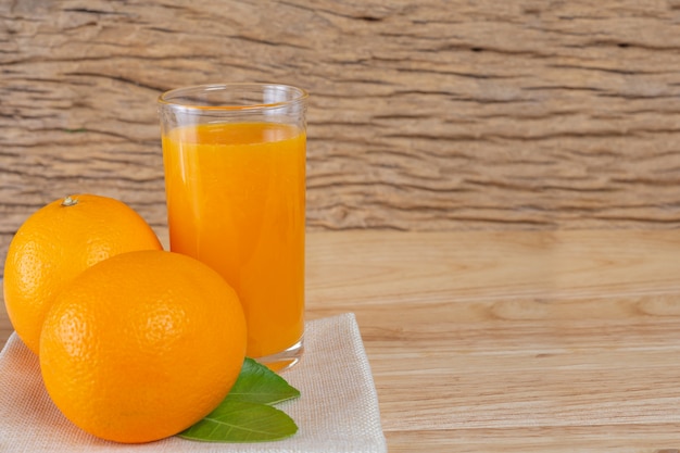 Vaso de jugo de naranja colocado en la madera.