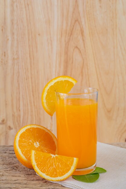 Vaso de jugo de naranja colocado en la madera.