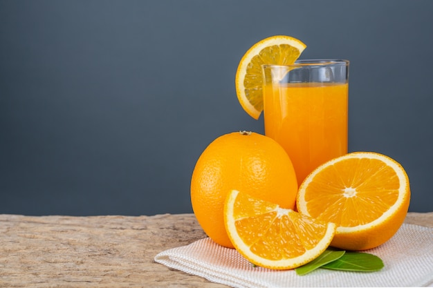 Vaso de jugo de naranja colocado en la madera.