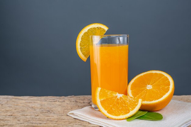 Vaso de jugo de naranja colocado en la madera.