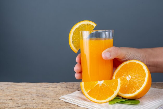 Foto gratuita vaso de jugo de naranja colocado en la madera.