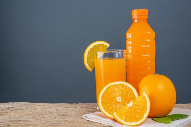 Vaso de jugo de naranja colocado en la madera.