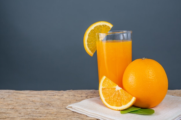 Foto gratuita vaso de jugo de naranja colocado en la madera.