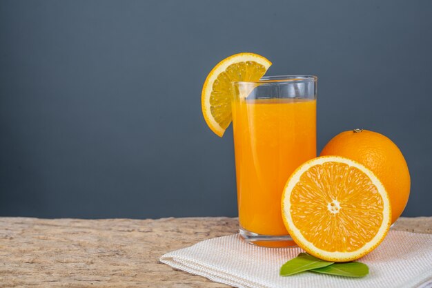 Vaso de jugo de naranja colocado en la madera.