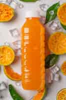 Foto gratuita un vaso de jugo de naranja y fruta fresca en el piso con cubitos de hielo.
