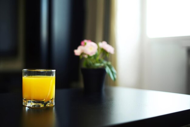 Vaso de jugo de naranja en interior oscuro