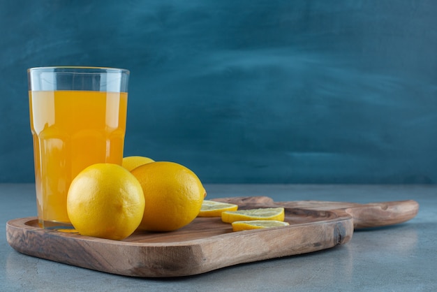 Foto gratuita un vaso de jugo de naranja con limones frescos.