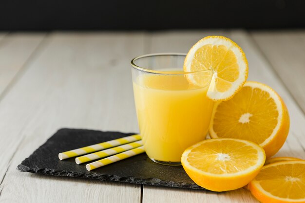 Vaso de jugo de naranja con pajitas