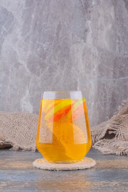 Foto gratuita un vaso de jugo de naranja sobre mármol.