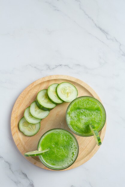 Vaso de jugo de pepino fresco sobre fondo de mármol