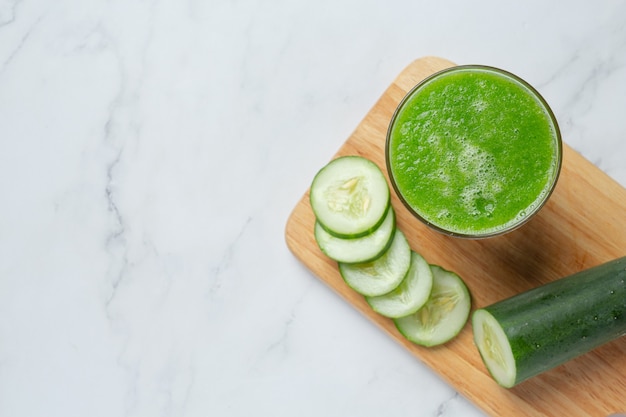 Vaso de jugo de pepino fresco sobre fondo de mármol