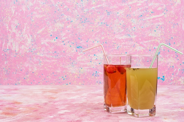 Foto gratuita un vaso de jugo verde con un vaso de jugo rojo.