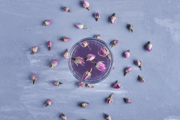 Un vaso de jugo de violeta con flores.