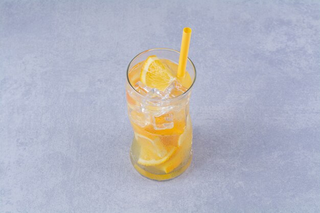 Un vaso de jugosa naranja, sobre el fondo de mármol.
