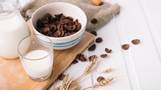 Vaso de leche y copos de chocolate seco en la mesa