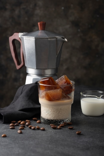 Vaso con leche y cubitos de hielo de café