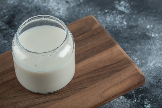 Vaso de leche fresca sobre tabla de madera