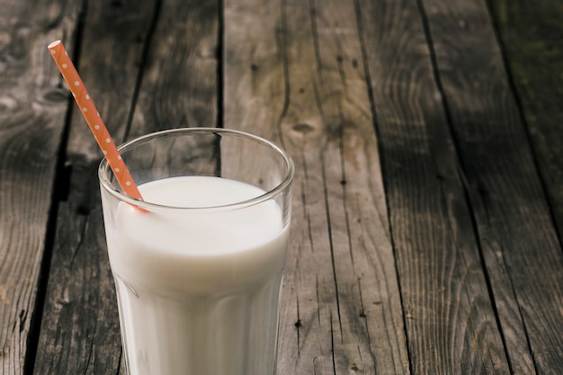 Vaso de leche con una pajita naranja