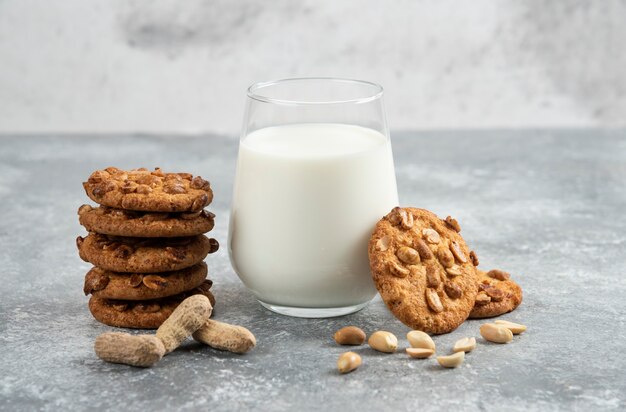 Vaso de leche y pila de galletas con miel en la mesa de mármol.