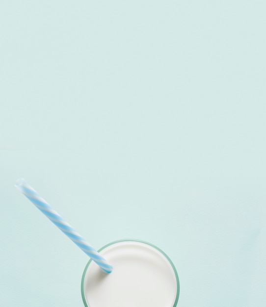 Vaso de leche sobre fondo azul con espacio de copia