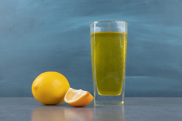 Un vaso de limonada con cubitos de hielo y rodajas de limón.