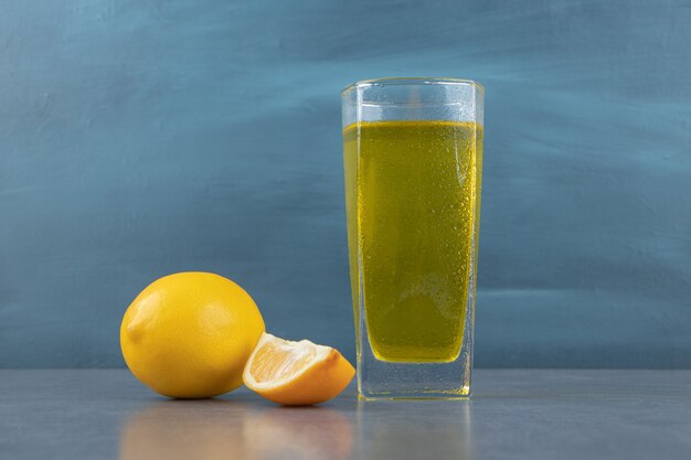Un vaso de limonada con cubitos de hielo y rodajas de limón.