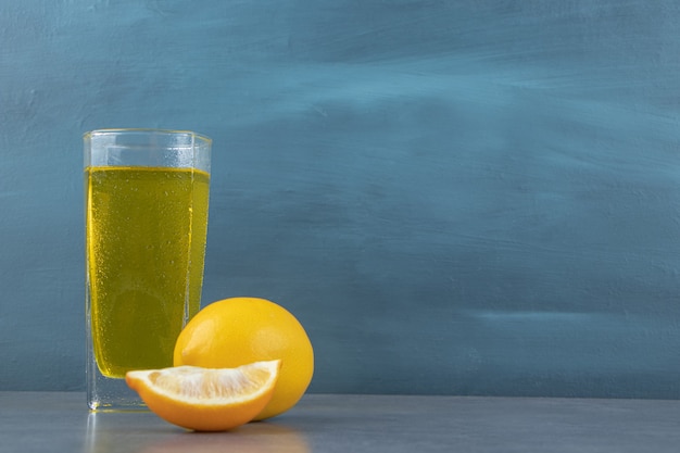 Un vaso de limonada con cubitos de hielo y rodajas de limón.