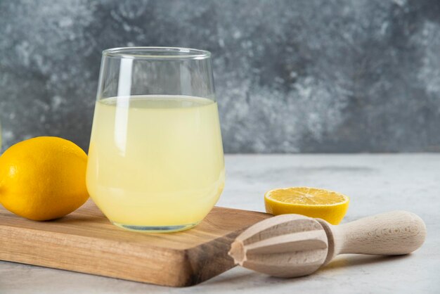 Un vaso de limonada y un escariador de madera.