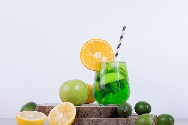 Vaso de limonada con naranja, feijoa sobre plancha de madera