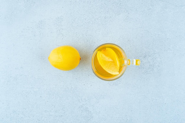 Vaso de limonada con rodajas de limón en azul