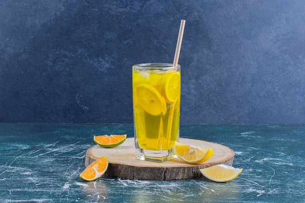 Un vaso de limonada con rodajas de limón sobre la superficie de mármol.