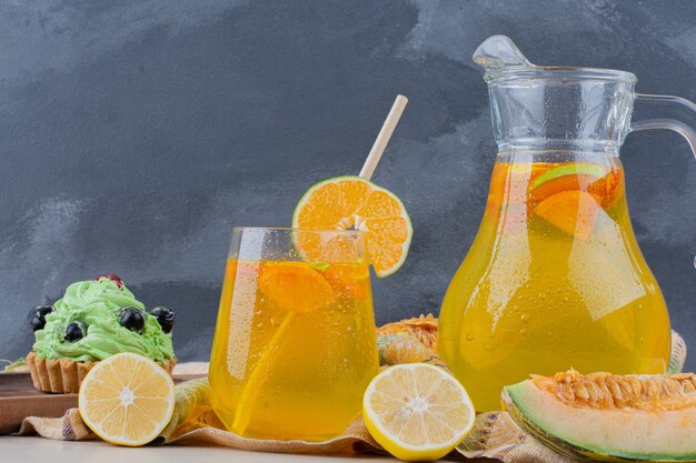 Vaso de limonadas con rodajas de limón en azul.