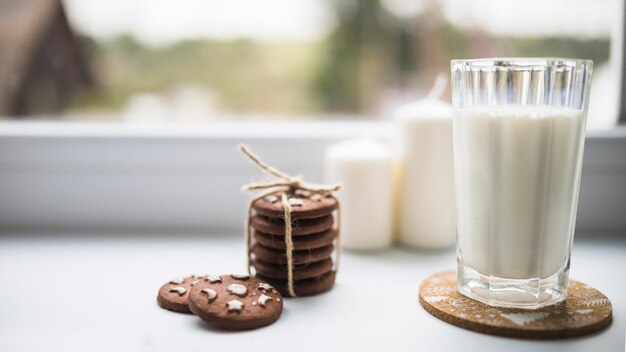 Vaso de líquido blanco cerca de galletas.