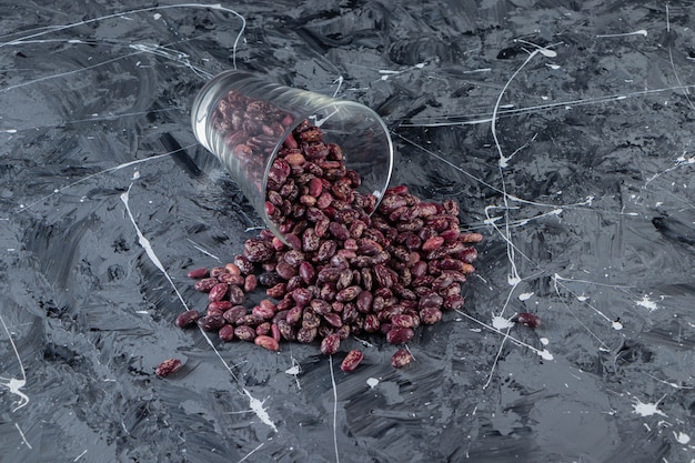 Vaso lleno de frijoles crudos colocados sobre la mesa de piedra.