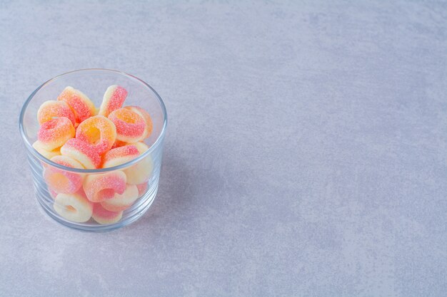 Un vaso lleno de mermeladas azucaradas de frutas coloridas