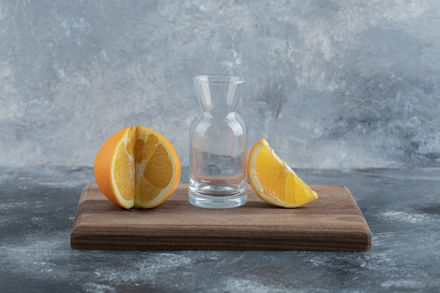 Foto gratuita vaso naranja y vacío sobre tabla de madera.