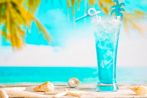 Vaso de refrescante bebida azul y estrellas de mar.