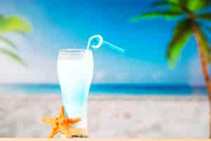 Foto gratuita vaso de refrescante bebida azul con paja y estrellas de mar.