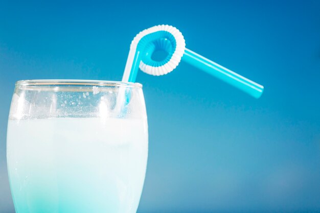 Vaso de refrescante bebida azul con paja