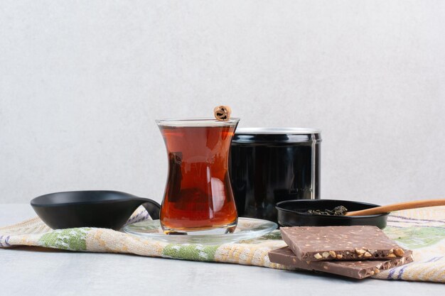 Vaso de té con chocolate con nueces sobre un mantel