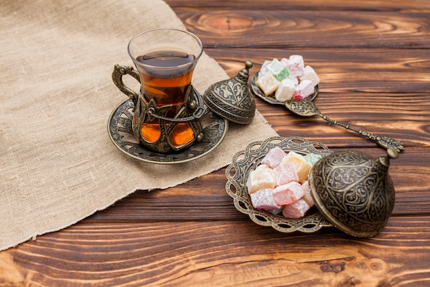 Vaso de té con delicias turcas en mesa